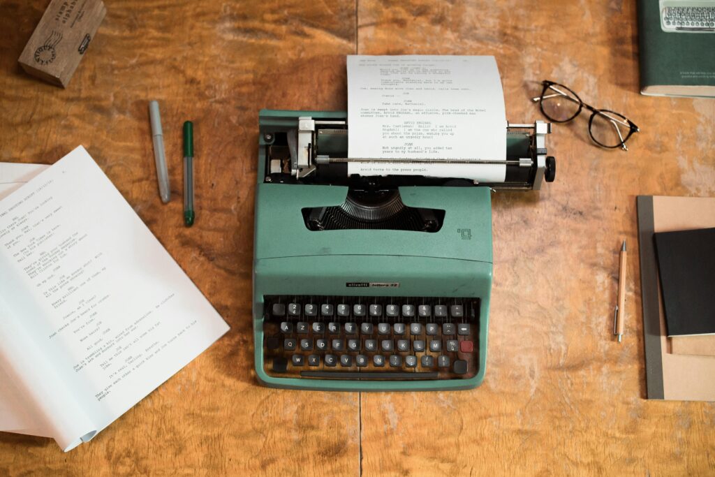 Green and black typewriter on brown wooden table